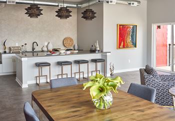 a dining room table with a vase of flowers on it at Vue Apartments, Des Moines, IA